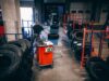 Warehouse where tires are lying around. There is an employee in the room making and doing