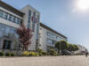 Entrance to the reifencom administration building. The building is white and the reifencom logo can be seen at the front.